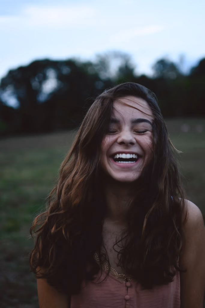 Femme brune qui rit en extérieur